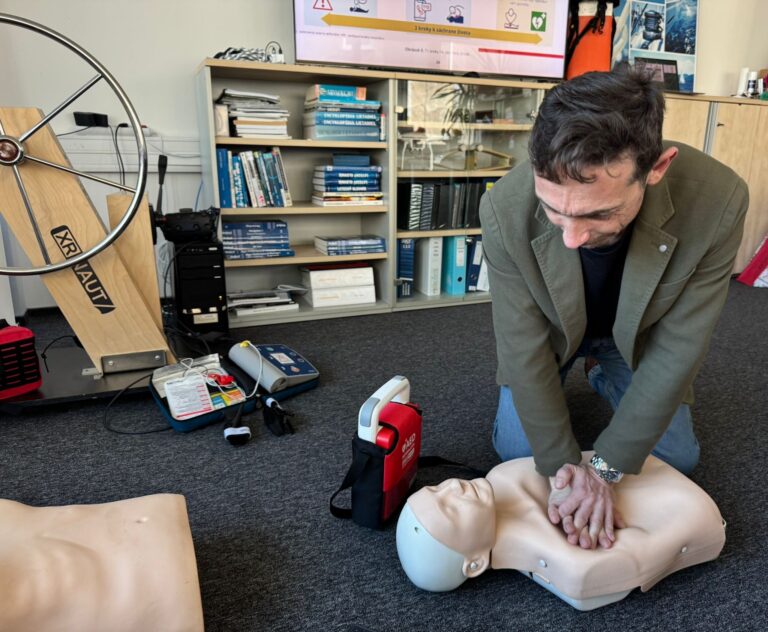 Účastník kurzu cvičí KPR s tréningovým AED defibrilátorom